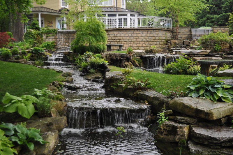 paysagiste-CUEBRIS-min_landscaping-rock-louisville-ky-traditional-landscape-and-boulders-brick-wall-bushes-grass-koi-law